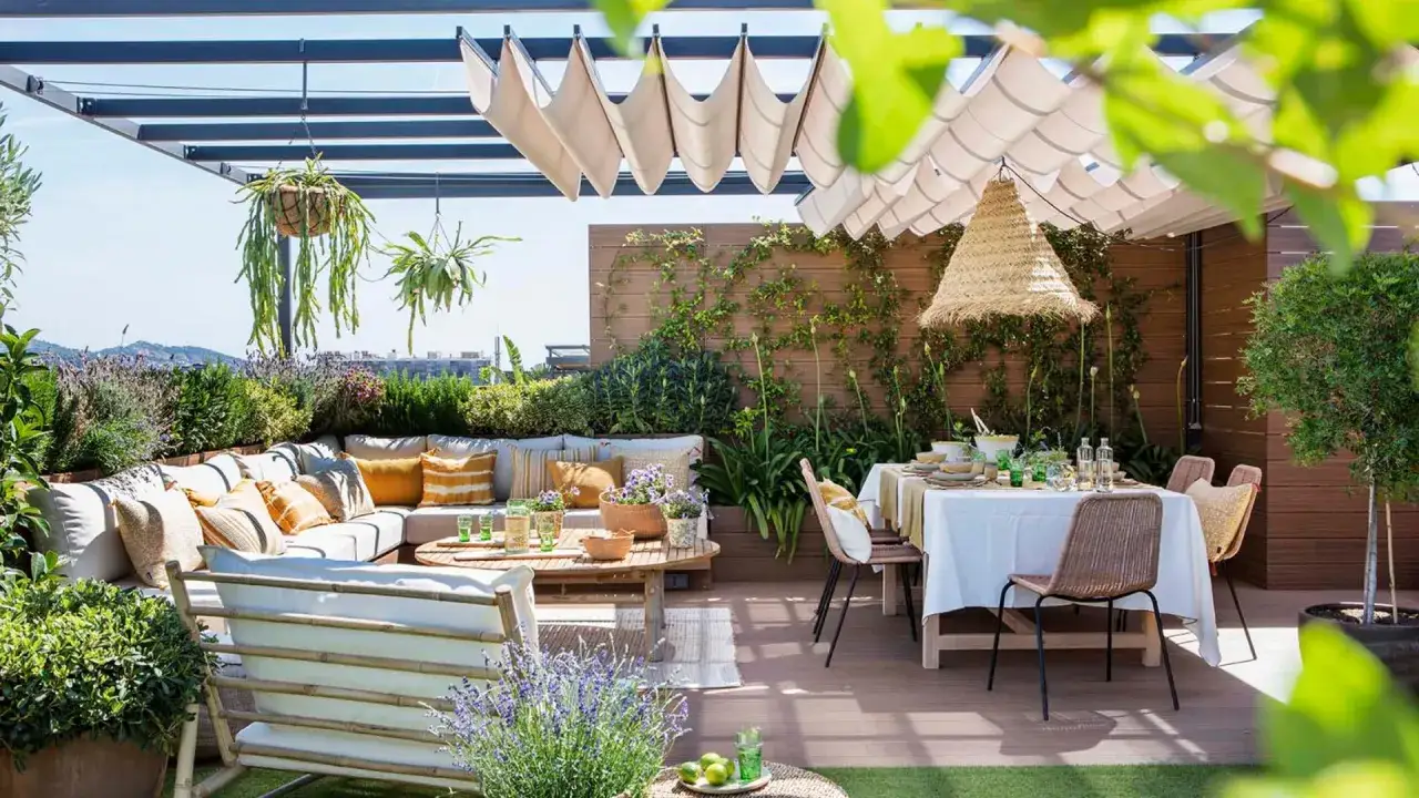 Acogedora terraza estilo mediterráneo con sofá, mesa de comedor y abundante vegetación. Un oasis de paz para disfrutar del buen tiempo.