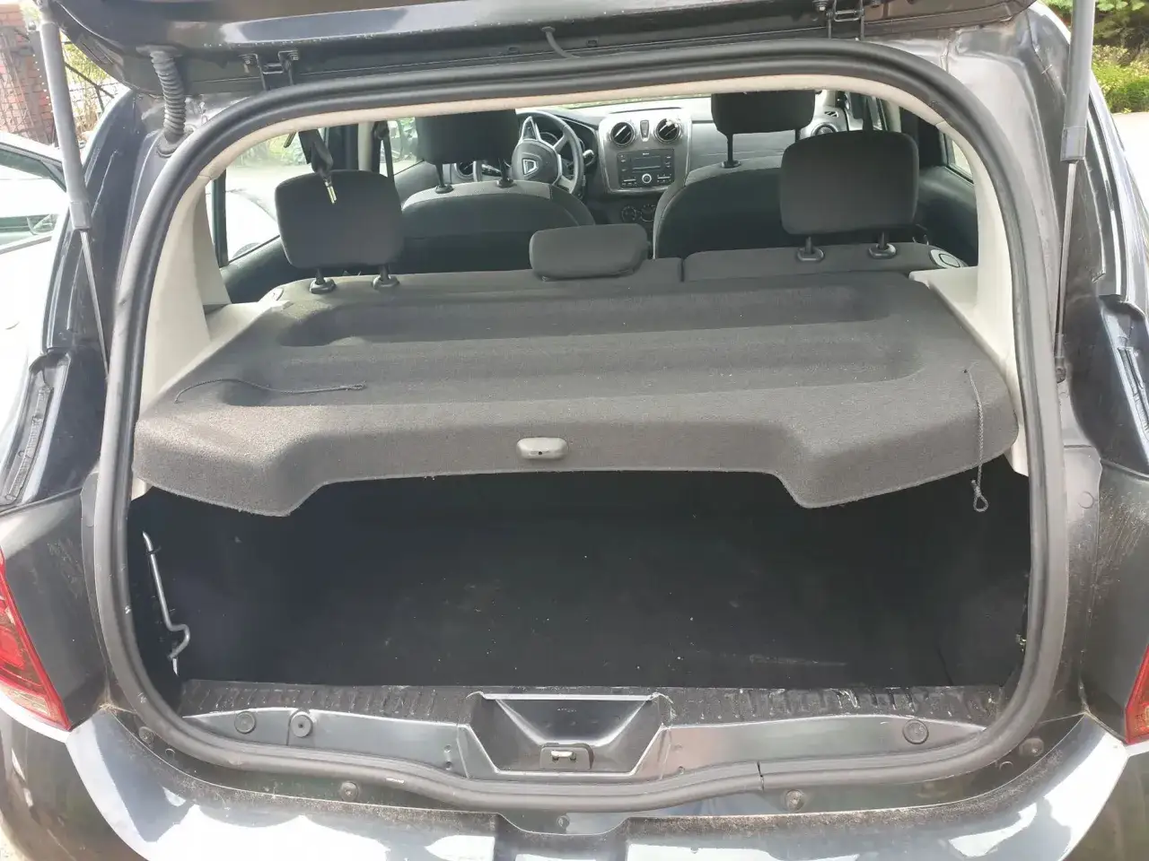 Wnętrze bagażnika Dacia Solenza z widocznymi siedzeniami i półką. Gotowy na podróż!