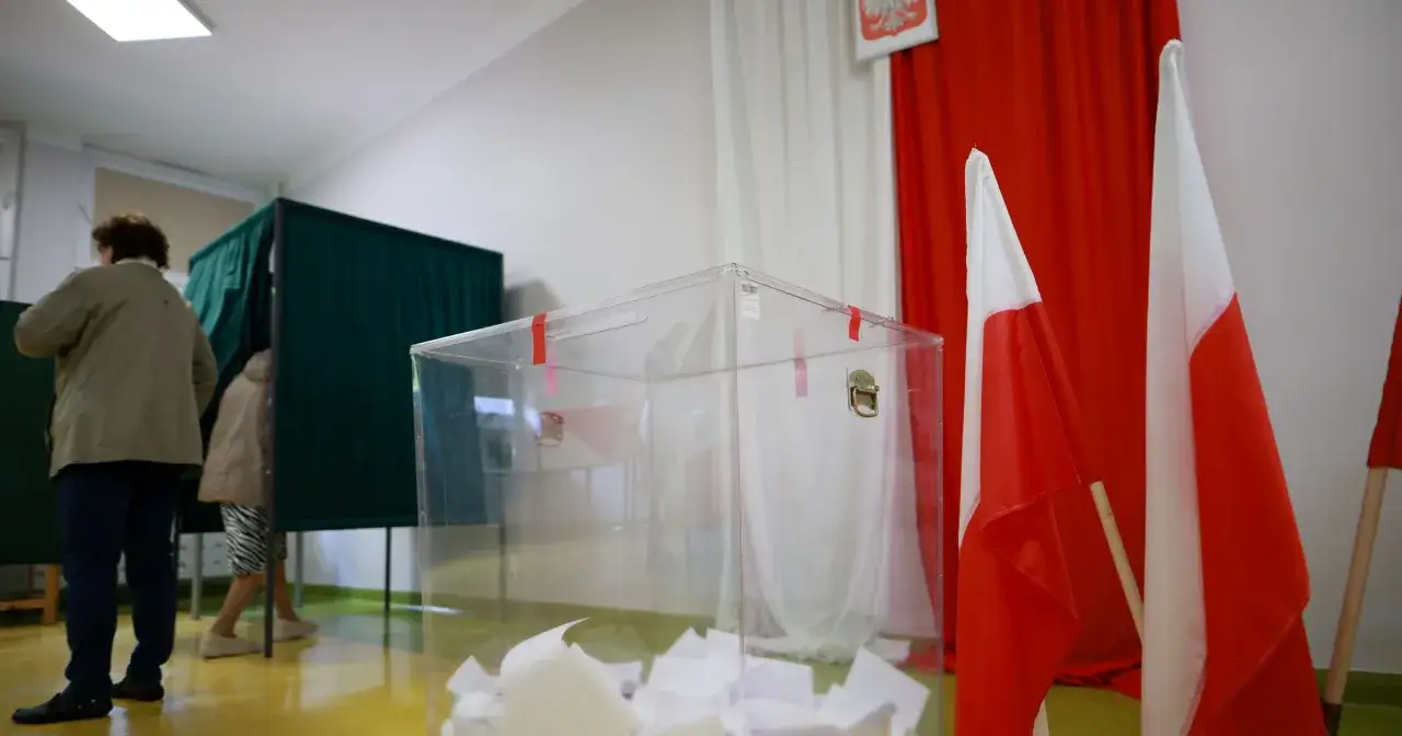Wybory w Polsce. Głosowanie za granicą jest możliwe. Widać urnę wyborczą, kabiny i polskie flagi.
