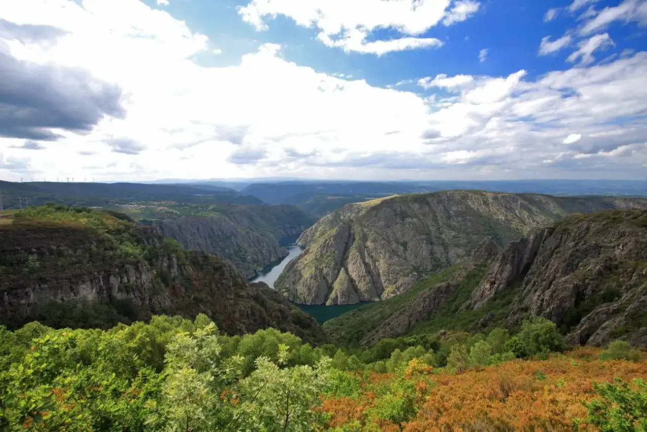 Impresionante vista desde el mirador Vilouxe, con un río serpenteando entre montañas escarpadas y vegetación frondosa.