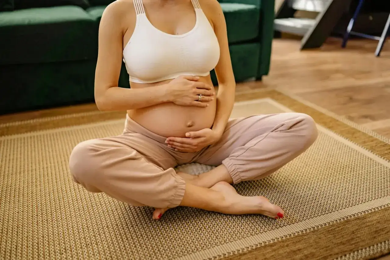 Gravid kvinna med händer på magen, bekvämt klädd. Frågan om laser hårborttagning gravid är vanlig.