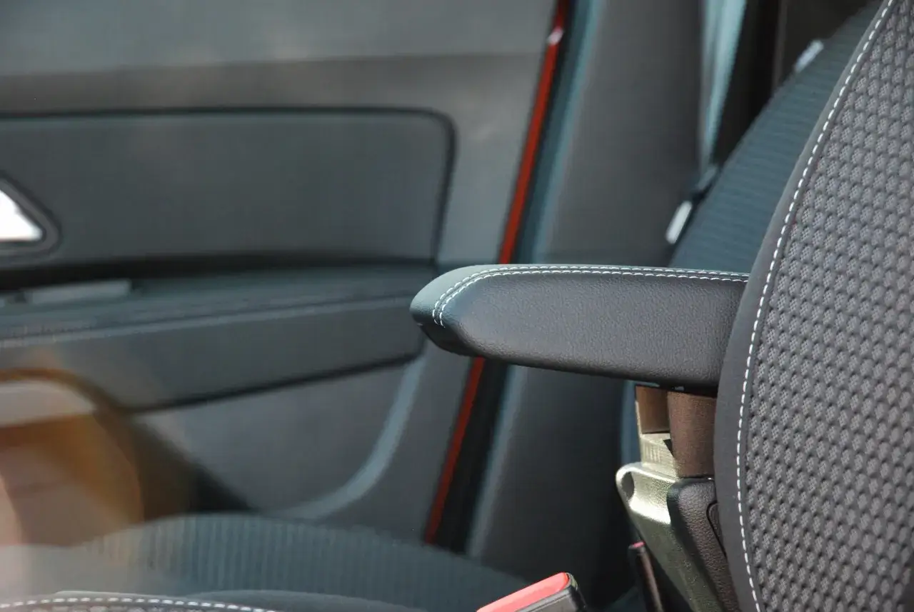 Wygodny podłokietnik Dacia Duster z białym przeszyciem, idealny na długie podróże.