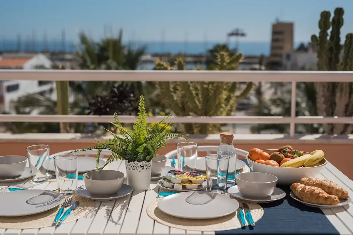 Desayuno en la terraza con vistas al puerto deportivo Aguadulce. Fruta fresca, cruasanes y un toque verde.