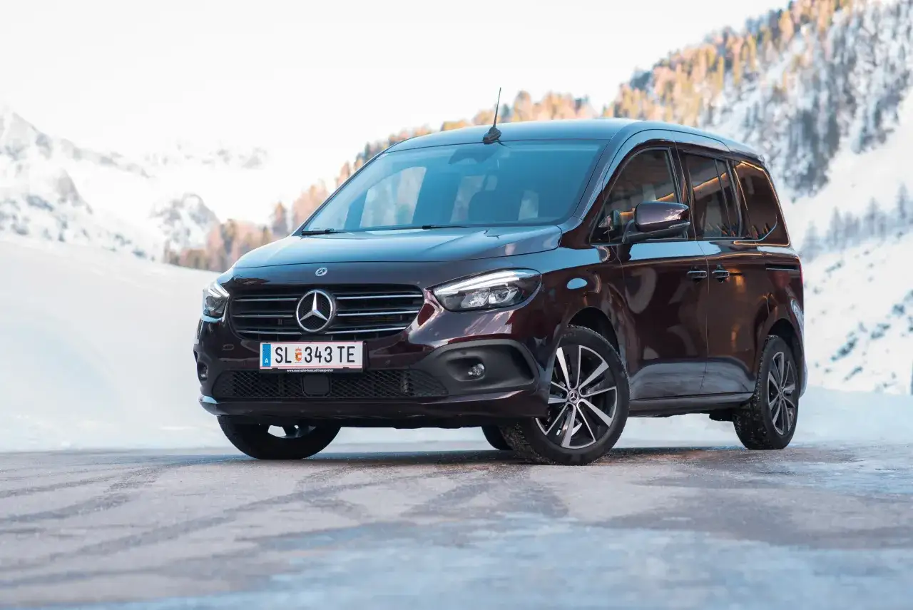 Dunkelroter Mercedes T 180 d im Schnee. Technische Daten sind hier nicht ersichtlich, aber das Fahrzeug ist bereit für winterliche Abenteuer.