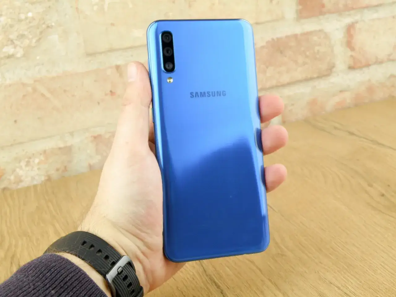 Niebieski Samsung Galaxy A50 w dłoni. Sprawdź aktualną samsung galaxy a50 cena i możliwości tego smartfona.