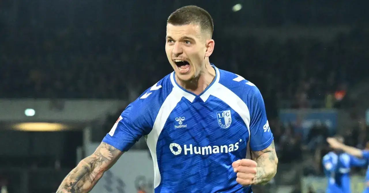 Piłkarz w niebieskiej koszulce 1. FC Magdeburg, z tatuażami na ramieniu, świętuje bramkę. Kolejny z Polaków w Bundeslidze pokazuje swoją pasję.