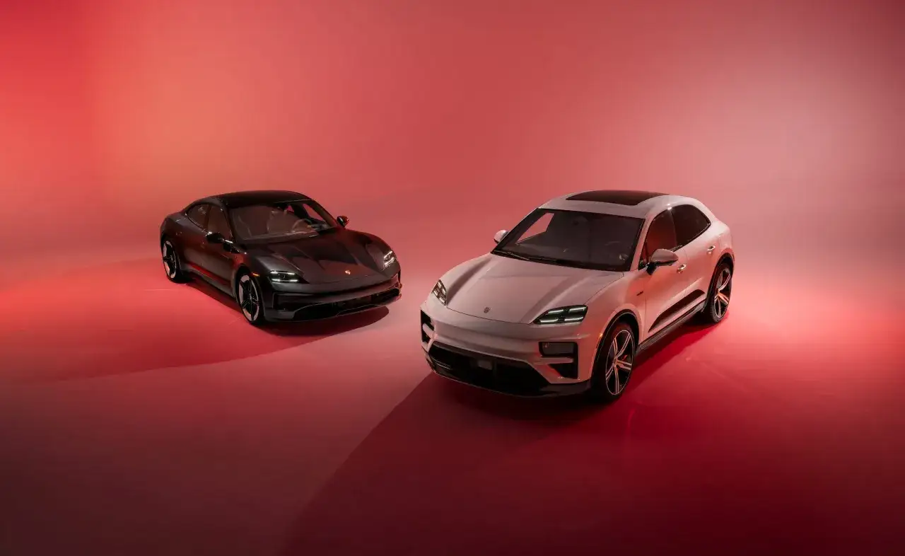 Dwa porsche elektryczne, czarne i białe, prezentują się na tle czerwieni.
