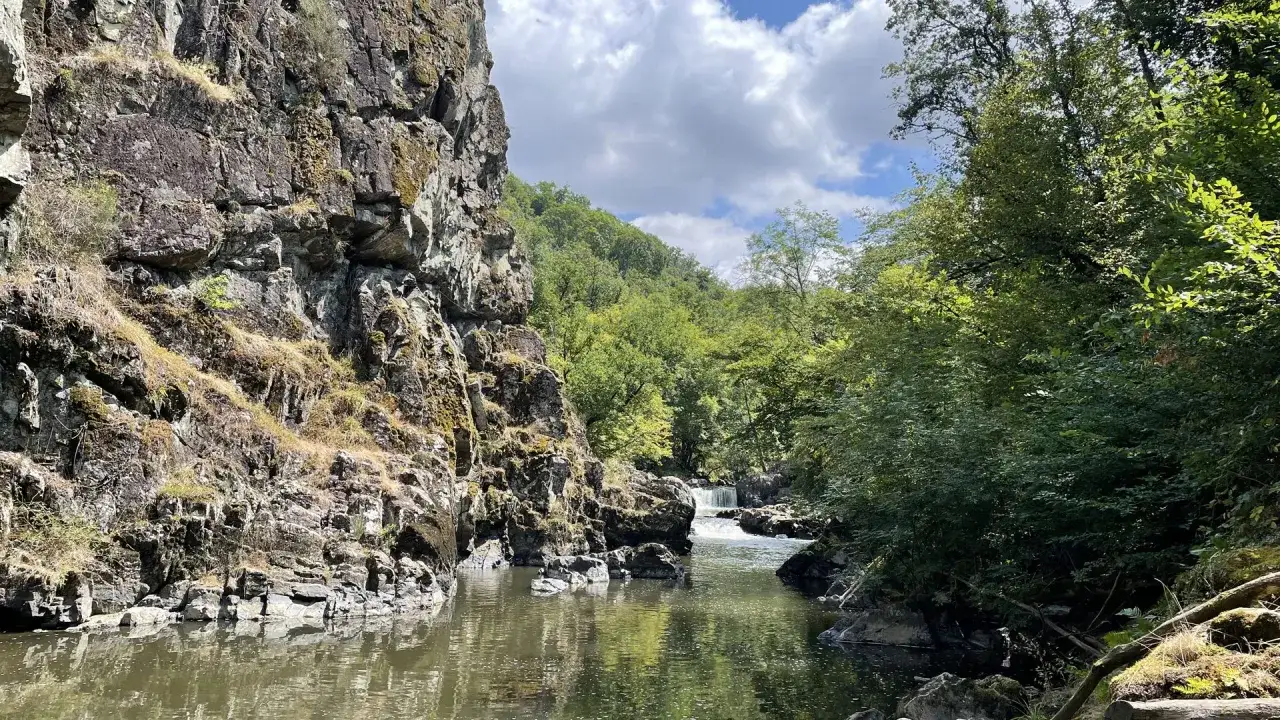 La cascade du Saut du Ruban se dévoile entre falaises rocheuses et végétation luxuriante, un spectacle naturel saisissant.