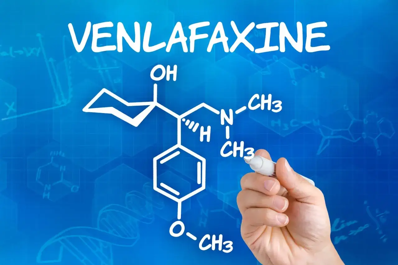 Rysunek chemiczny wenlafaksyny, leku często przepisywanego w dawce 150 mg, na niebieskim tle z wzorami chemicznymi.
