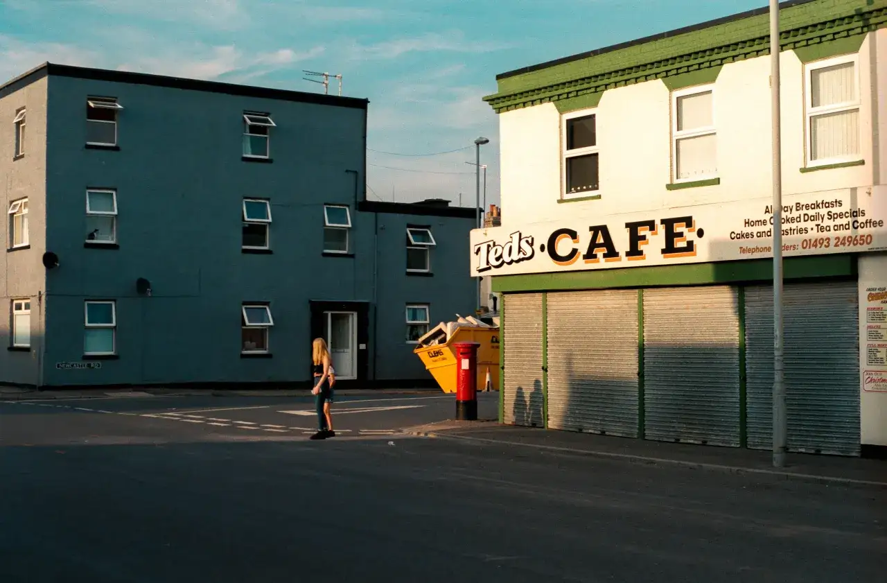 Une jeune femme traverse la rue devant le café