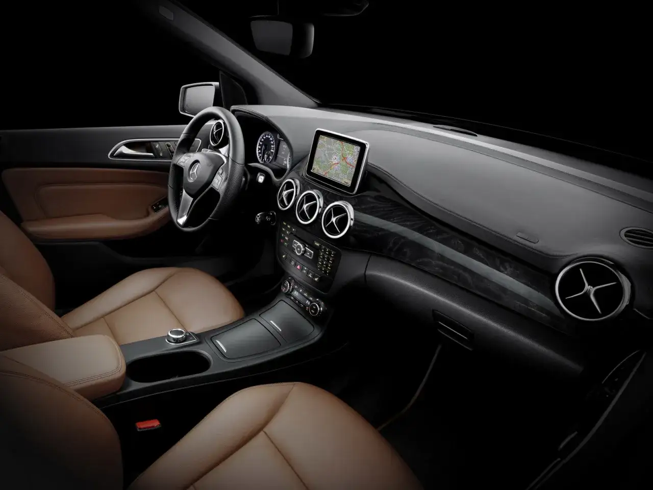 Interni lussuosi con sedili in pelle color caramello e un cruscotto moderno. Il volante multifunzione e il display centrale con navigatore suggeriscono un'esperienza di guida fluida grazie al cambio semiautomatico Mercedes.