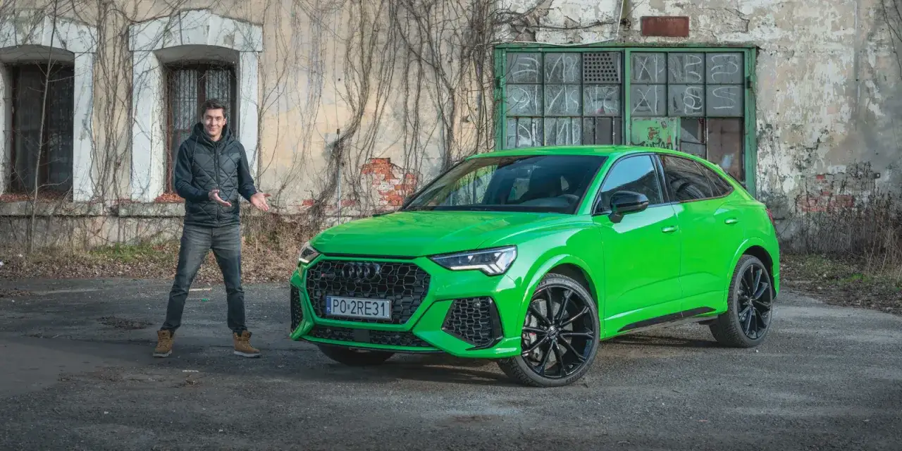 Mężczyzna prezentuje jaskrawozielone Audi RS Q3 przed zniszczonym budynkiem.