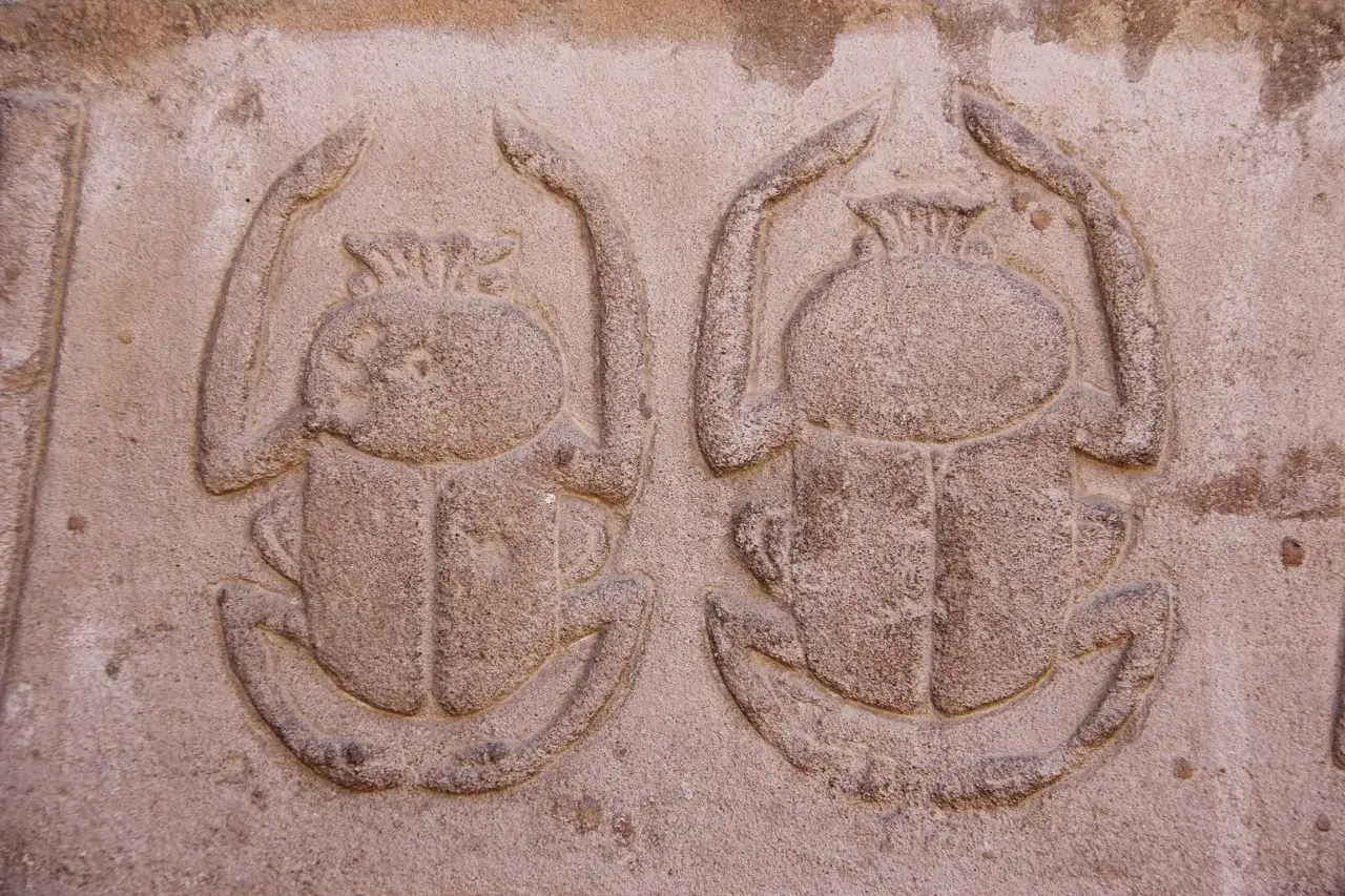 Deux scarab&eacute;es sculpt&eacute;s dans la pierre, symbole de renaissance et de protection.