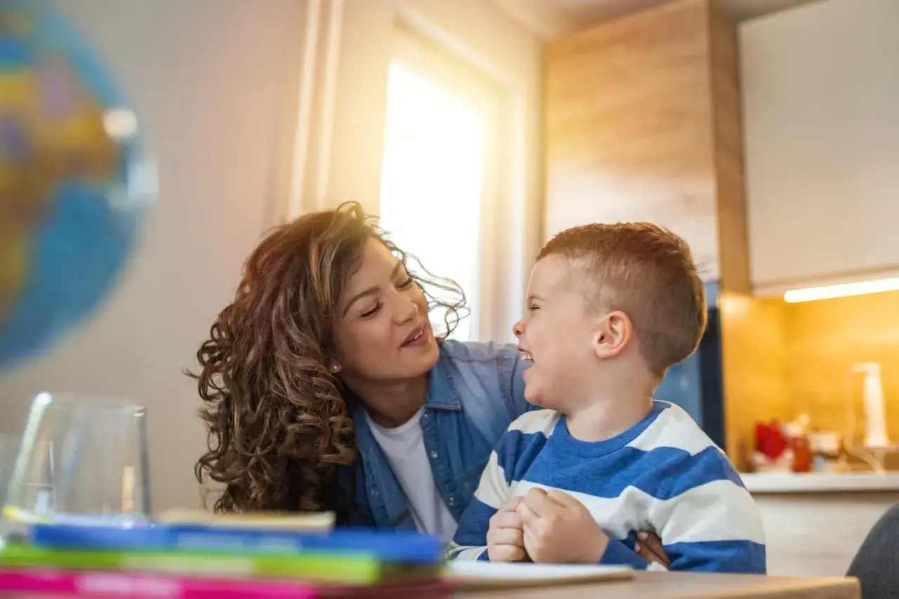 Mama i syn śmieją się do siebie, wspierając jego skoki rozwojowe po roku.