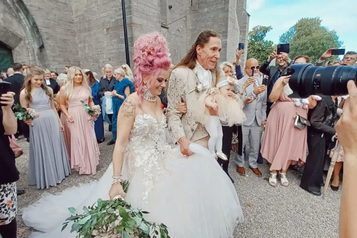 Bröllopspar med rosa hår och en bebis. Melinda Jacobs E-Type firar kärleken med en unik stil.