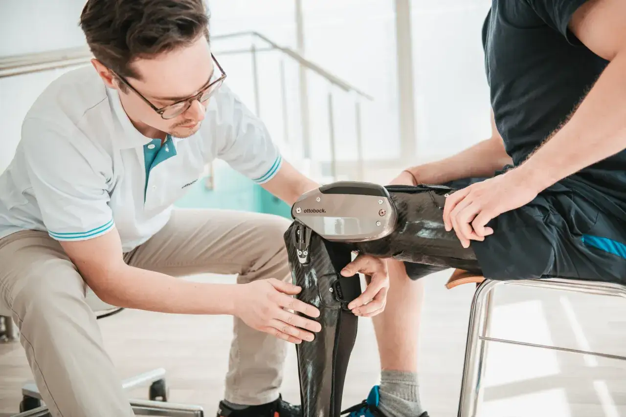 Ein Orthop&auml;dietechniker passt eine C-Brace Orthese an einem Patienten an.
