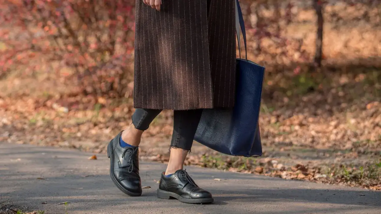 Eleganza autunnale: scarpe oxford donna outfit con cappotto a righe e borsa blu.