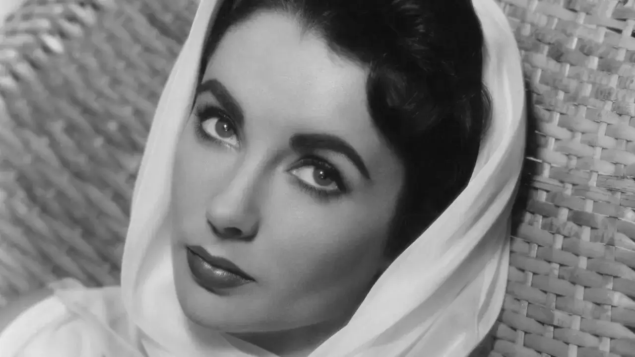 Portret Elizabeth Taylor, jednej z największych gwiazd kina. Jej spojrzenie przyciąga uwagę, a stylizacja przypomina o dawnych, legendarnych aktorkach.
