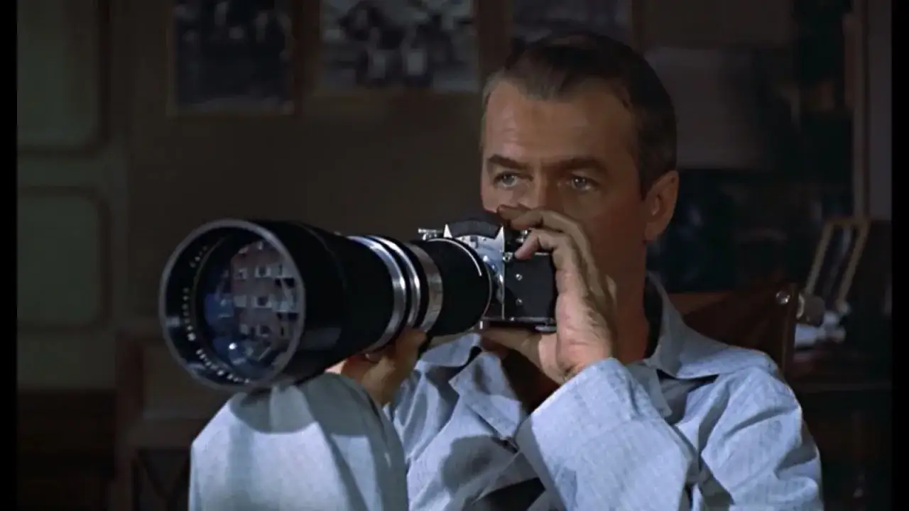 Mężczyzna z aparatem fotograficznym, uchwycony w chwili, gdy nikt nie patrzy, obserwuje świat przez obiektyw.