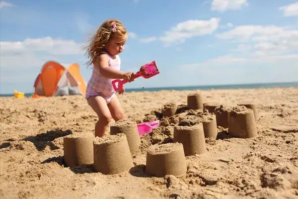 Dzieci bawiące się na plaży, zabawki do piasku