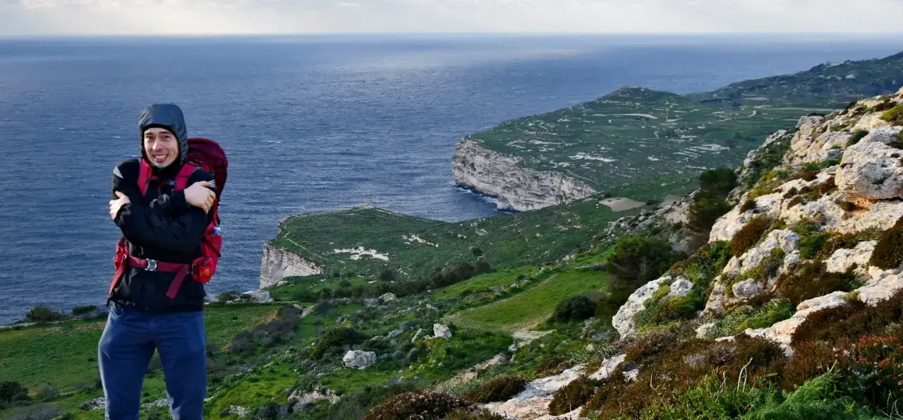 Turysta na tle klifów Malty i Gozo. Odkryj najciekawsze trasy spacerowe wzdłuż wybrzeża.