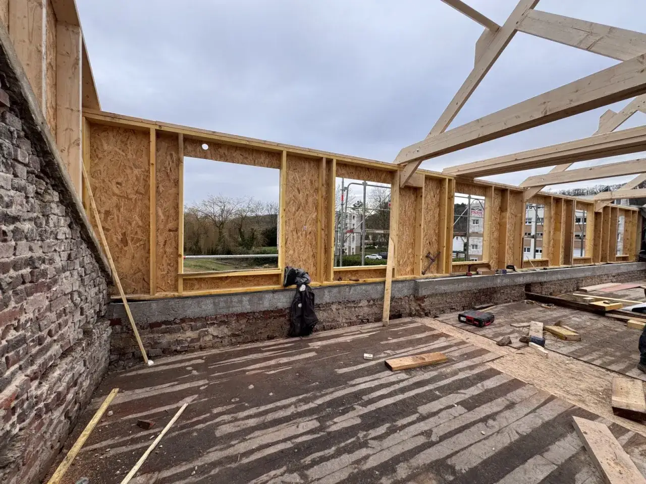 Ossature en **épicea bois** pour une nouvelle construction. Les murs sont en cours d'assemblage, avec des ouvertures pour les fenêtres.