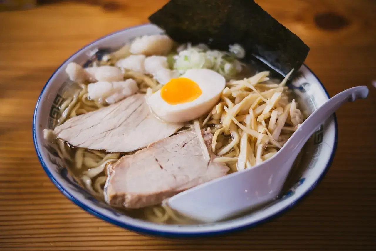 Miseczka ramenu z plastrami mięsa, jajkiem i bambusem. Czy można jeść ramen w ciąży? To danie wygląda apetycznie!
