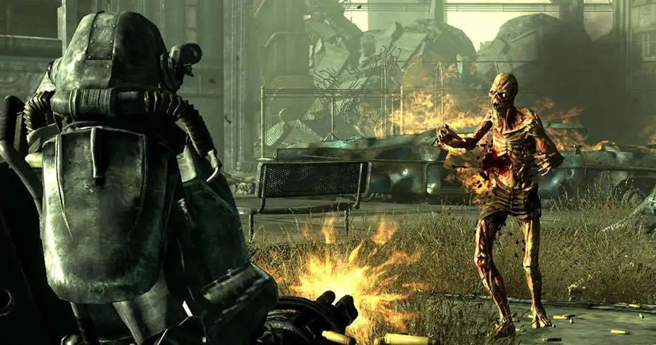 Gracz w pancerzu wspomaganym walczy z ghulem na tle płonących ruin. To scena z gry, która może pojawić się w **Fallout 3 poradnik**.