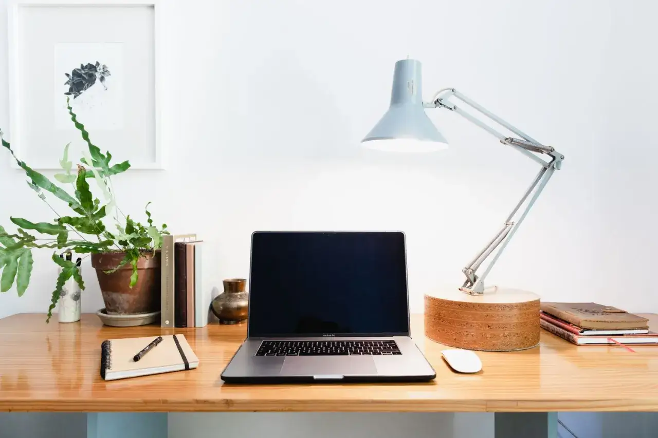 Ein **home office** mit Laptop, Lampe, Pflanze und Büchern. Perfekt für produktives Arbeiten.