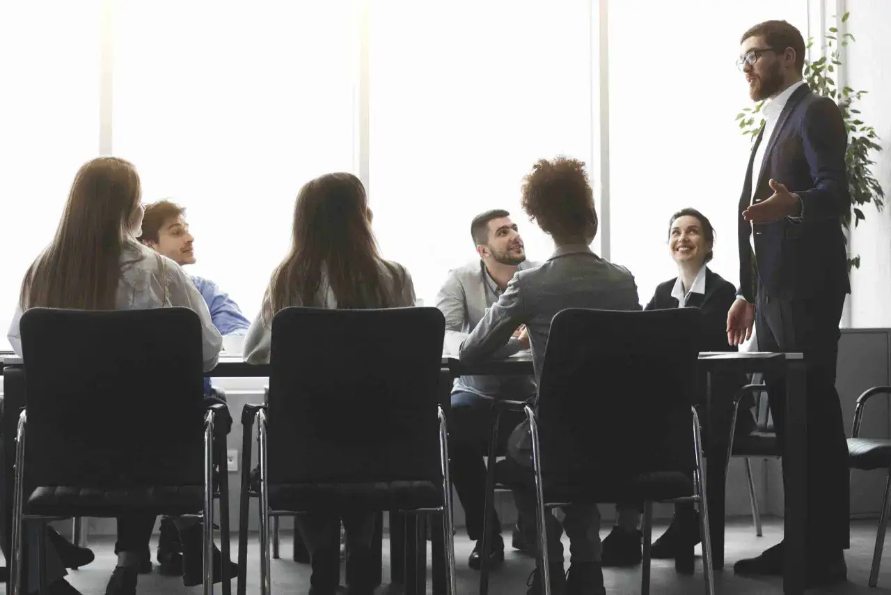 Un hombre con gafas da una charla a un equipo. Aprende c&oacute;mo ser un CEO exitoso.