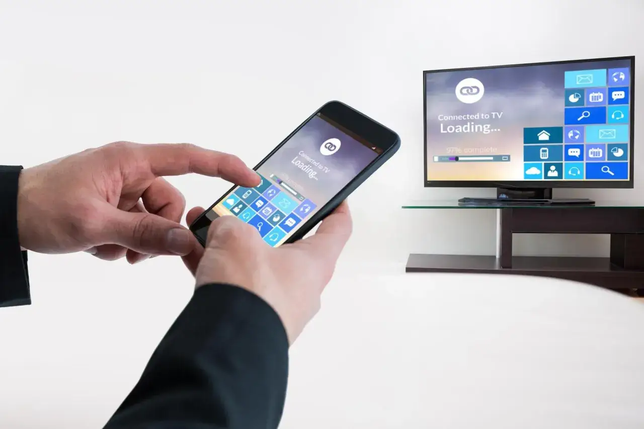 Dłonie trzymają smartfon, który pokazuje ekran