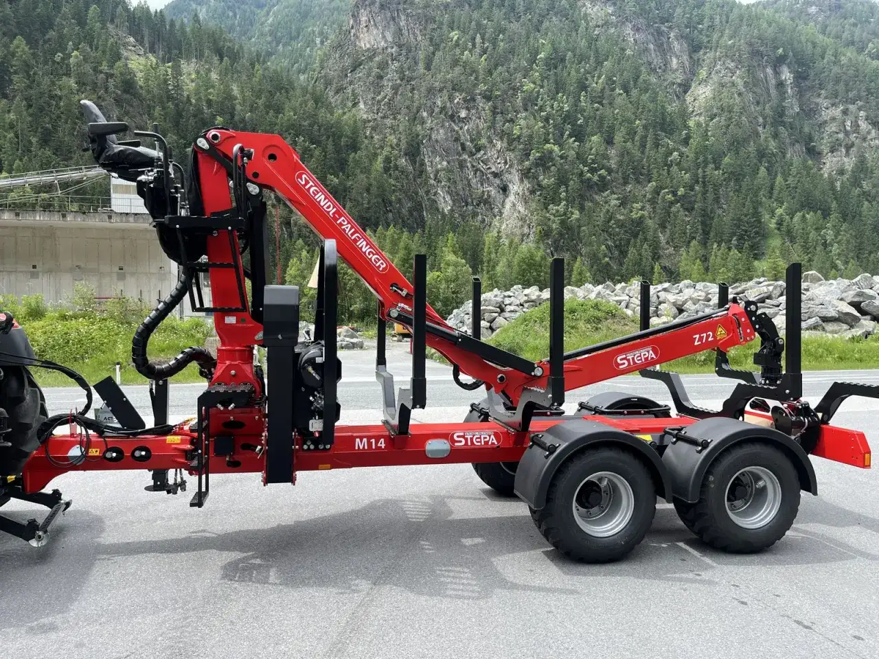 Roter Forstkran gebraucht von Steindl-Palfinger, Modell M14 mit Z72-Greifer, bereit für den Einsatz im Wald.