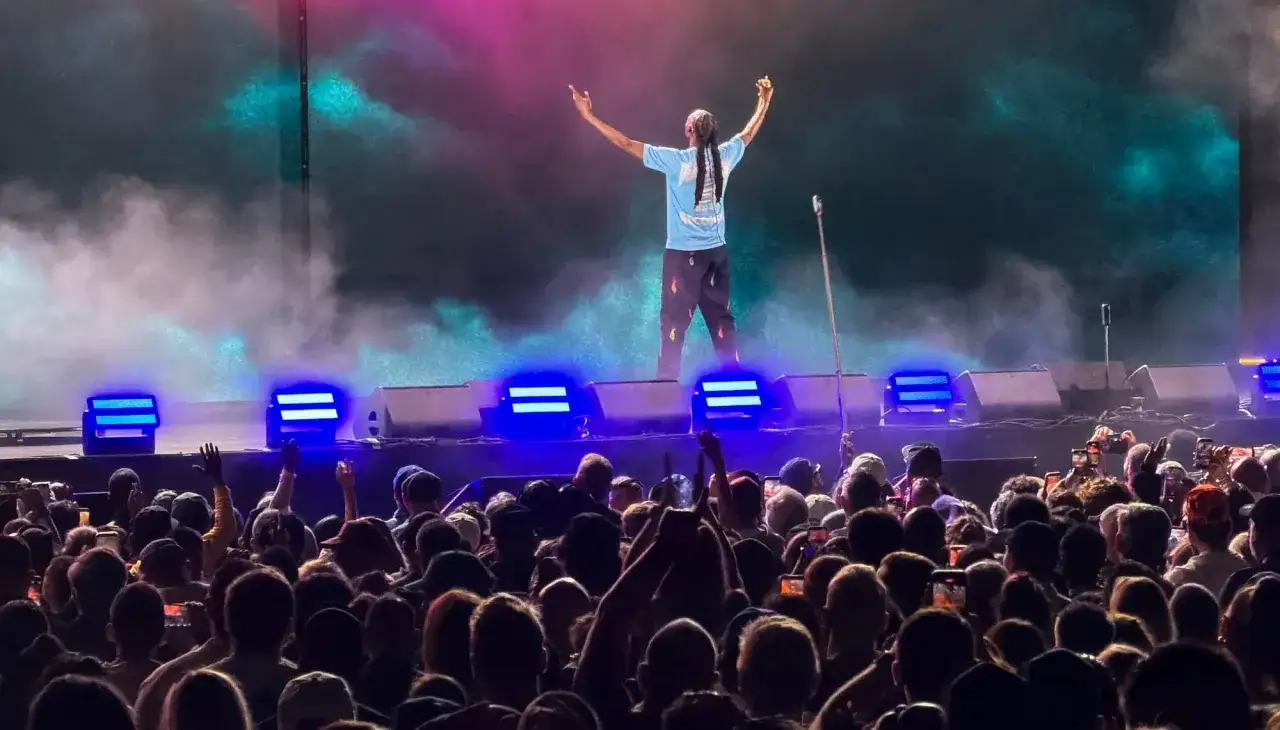 Snoop Dogg na scenie, tłum szaleje do jego utworów. Dym, światła i energia koncertu.