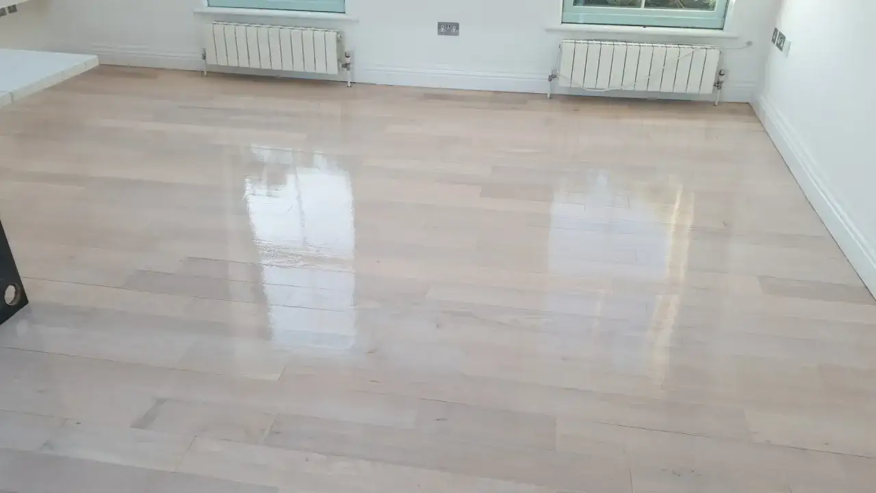 Suelo de madera reci&eacute;n pulido, con un acabado blanquecino y brillante. El proceso de recuperar parquet blanquecino ha dejado el suelo como nuevo.