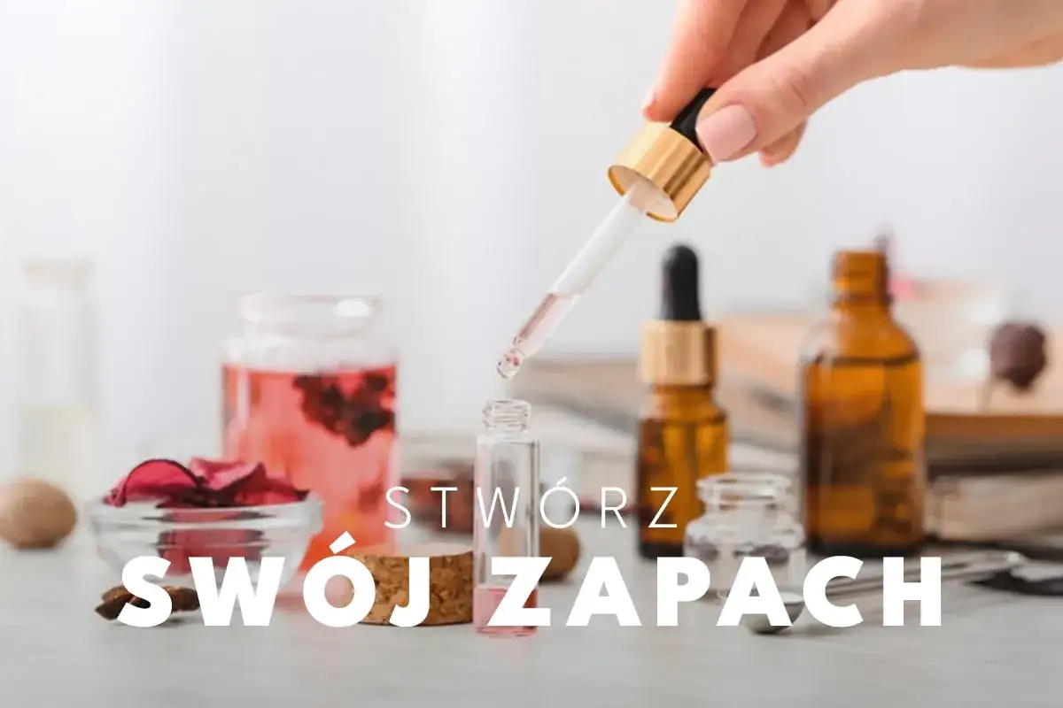 Tworzenie perfum: pipetka z różowym płynem dodaje kroplę do małej buteleczki. W tle widać butelki z olejkami i płatki róż. Jaki alkohol do perfum?