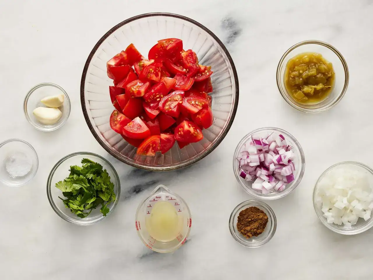 Składniki na świeże pico de gallo: pomidory, cebula, kolendra, czosnek, limonka, chili i przyprawy.