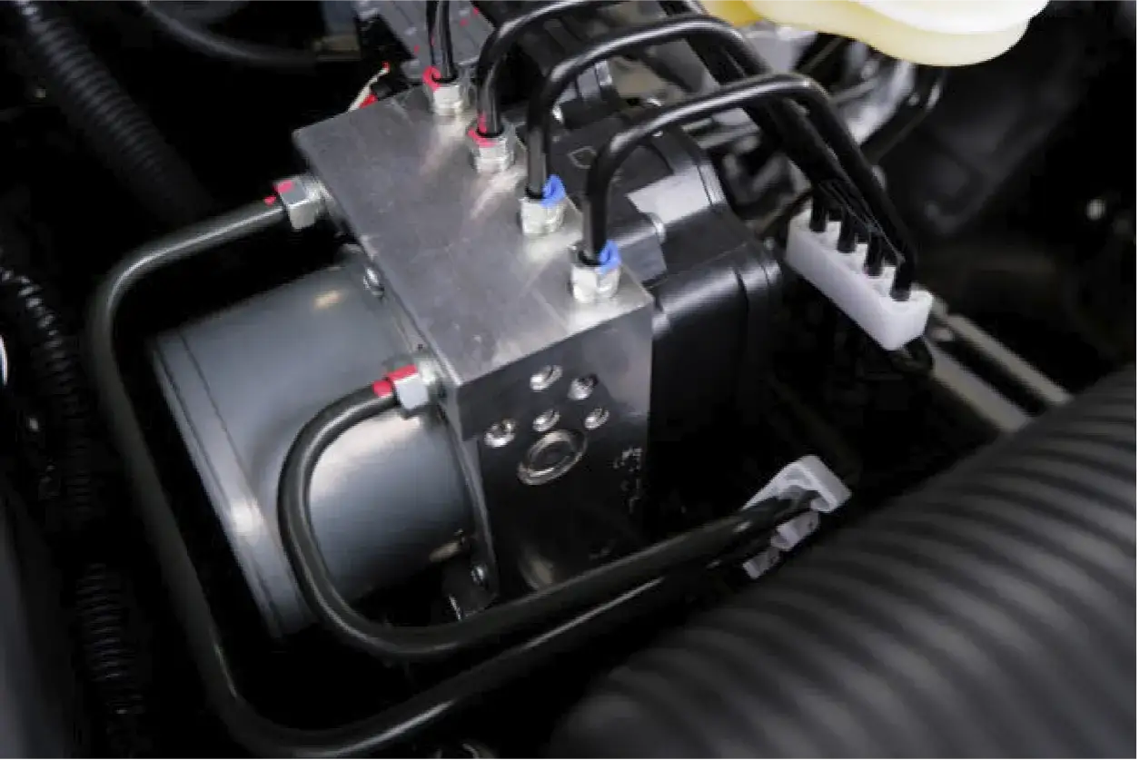 Close-up of a car's ABS hydraulic unit. ABS plastic is used for its durability in automotive components like this.