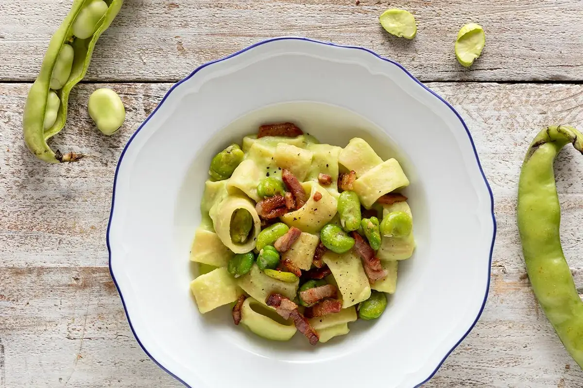 Piatto di pasta con fave fresche e croccante pancetta, un classico saporito.