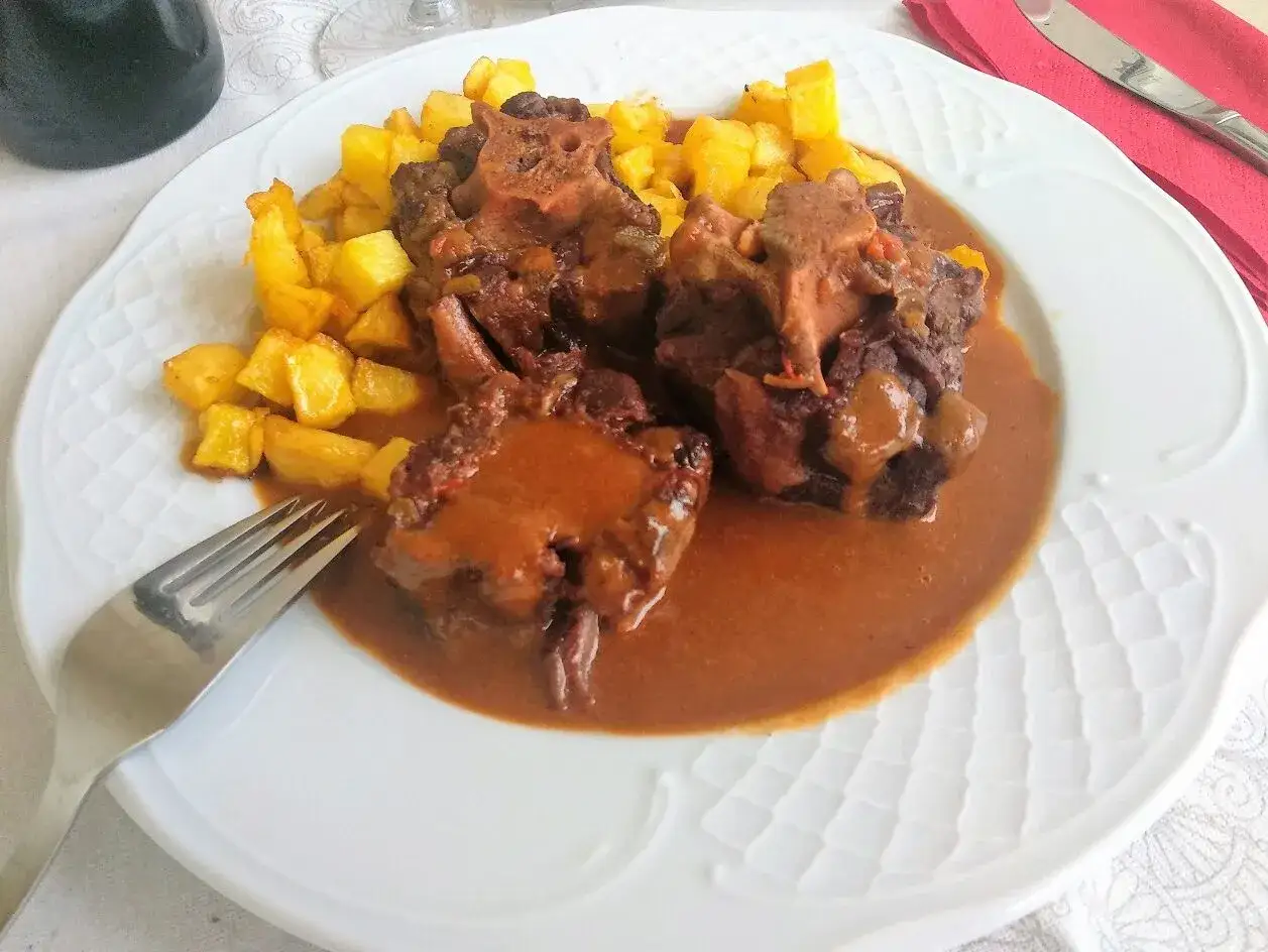 Plato de rabo de toro estofado en salsa con patatas fritas. Una deliciosa receta para disfrutar.