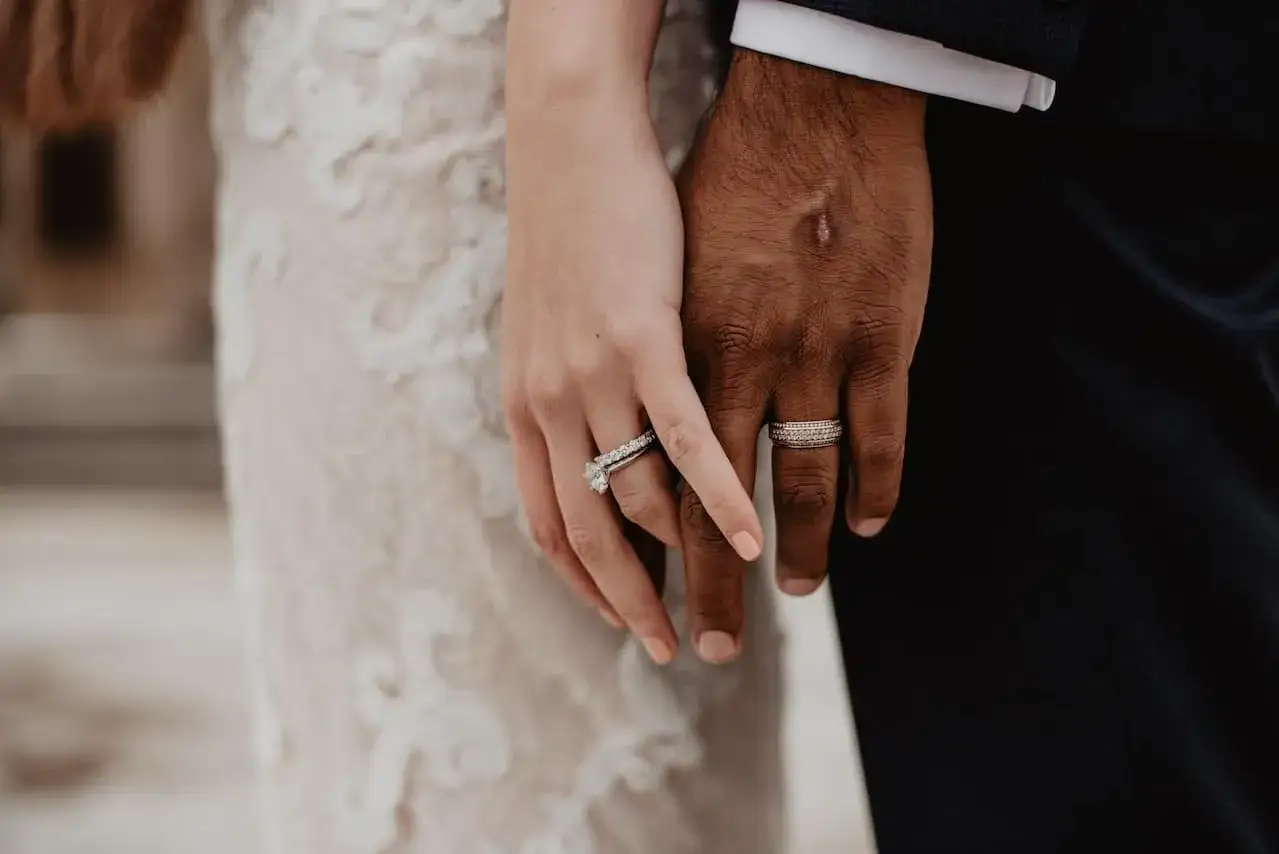 Manos entrelazadas, mostrando el anillo de matrimonio en la mano izquierda, como es tradición en España.