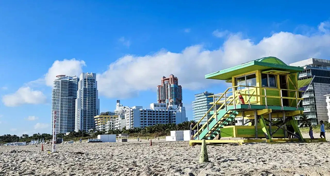 Słoneczna plaża w Miami z charakterystyczną wieżą ratowniczą. Idealny czas, kiedy jechać do Miami, by cieszyć się takim widokiem i błękitem nieba.