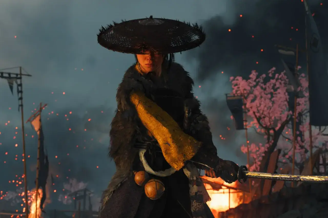 Guerriera con katana, sullo sfondo un campo di battaglia in fiamme e ciliegi in fiore. L'atmosfera evoca il **Ghost of Tsushima 2**.