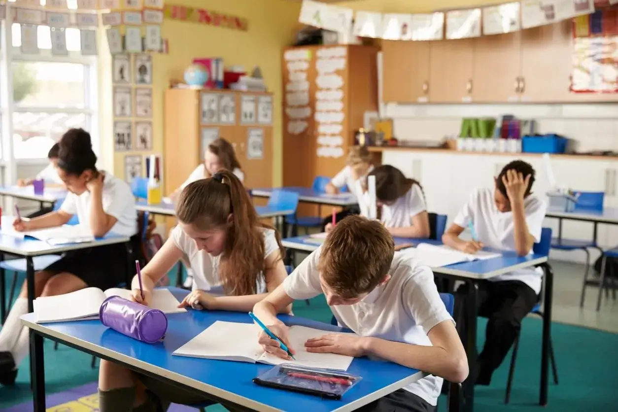 Sch&uuml;ler konzentriert in einem hellen Klassenzimmer, das auf **healing classrooms** hindeutet.
