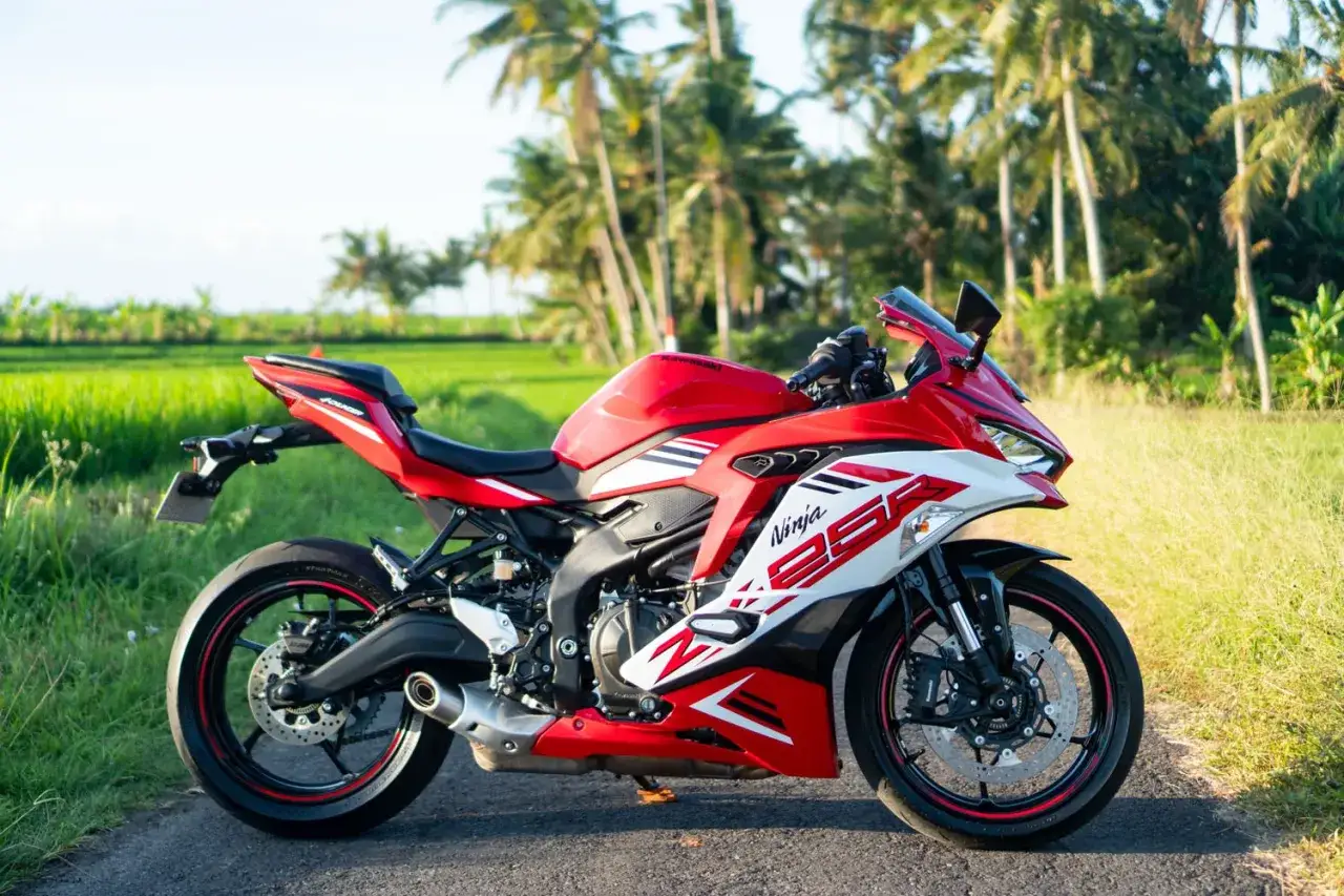 Kawasaki Ninja ZX-25R roja y blanca, lista para la aventura entre palmeras y arrozales.