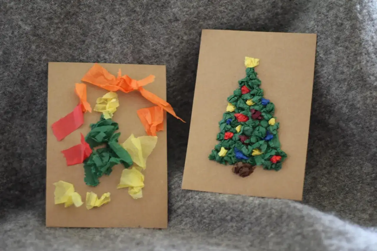 Två julkort med julgranar gjorda av papper. En gran är dekorerad med färgglada pappersbitar, som en julgranspynt. Den andra granen är mer abstrakt, med gröna, gula och orange pappersbitar. Båda korten är gjorda med tekniken papier mache.