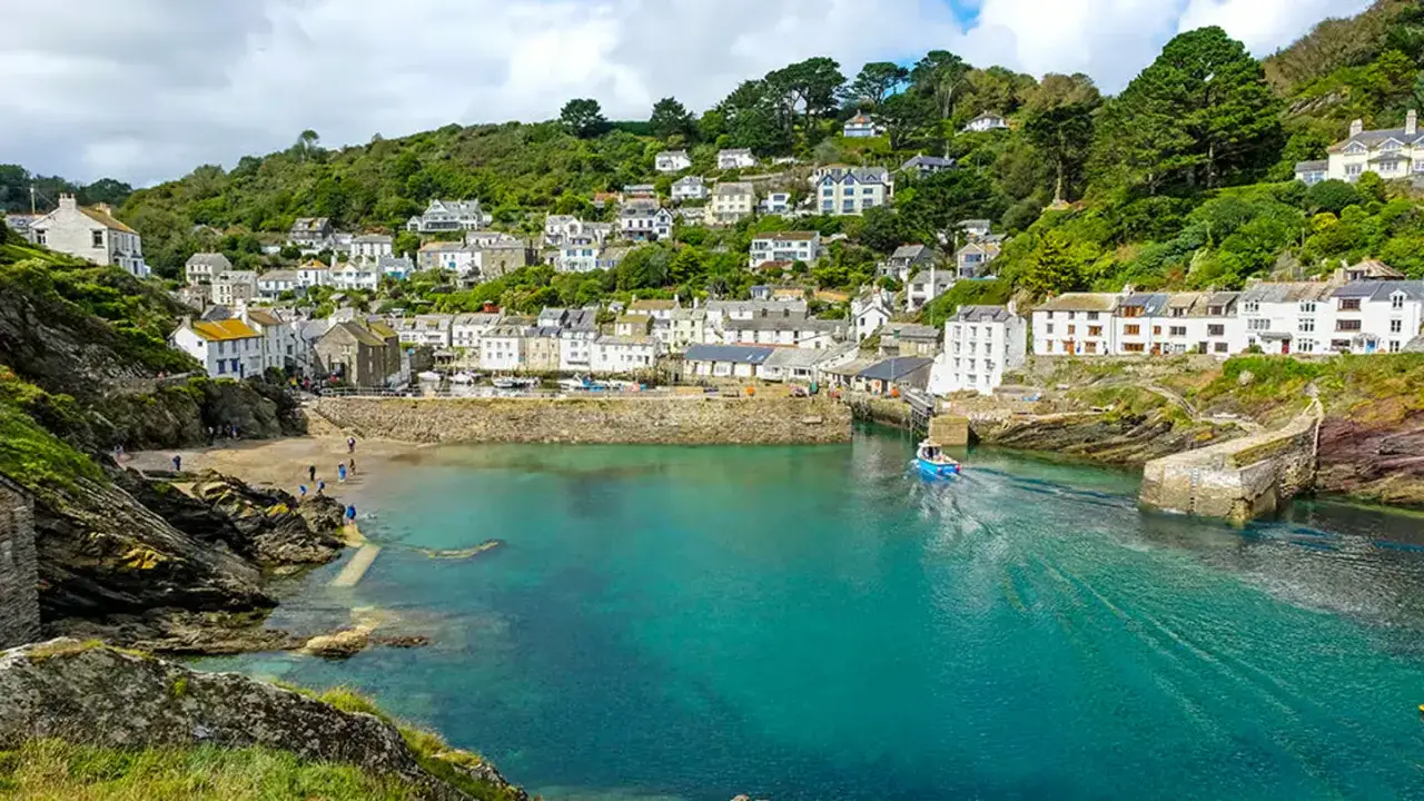 Idyllischer Hafenort in Cornwall, perfekt f&uuml;r einen England Urlaub. Wei&szlig;e H&auml;user schmiegen sich an gr&uuml;ne H&uuml;gel, das t&uuml;rkisfarbene Wasser l&auml;dt zum Tr&auml;umen ein.