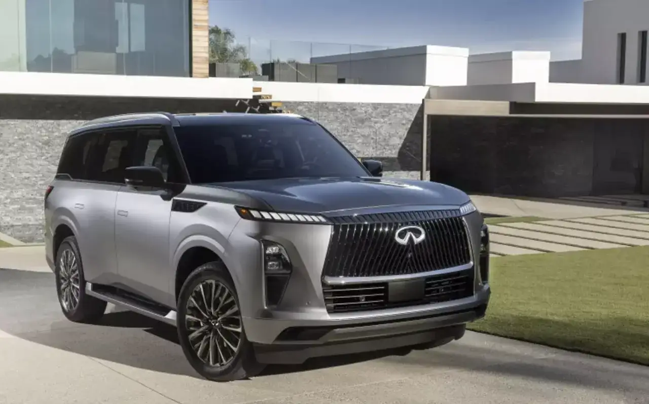 Elegancki, srebrny Infiniti SUV zaparkowany przed nowoczesnym domem.