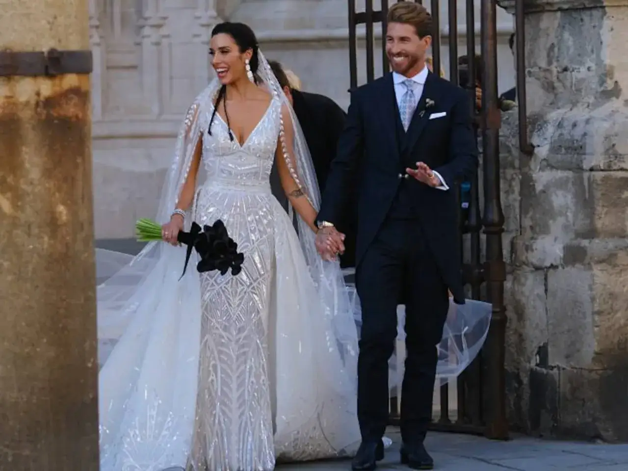 La feliz pareja en la boda de Pilar Rubio y Sergio Ramos, ella con un vestido brillante y &eacute;l con traje oscuro.