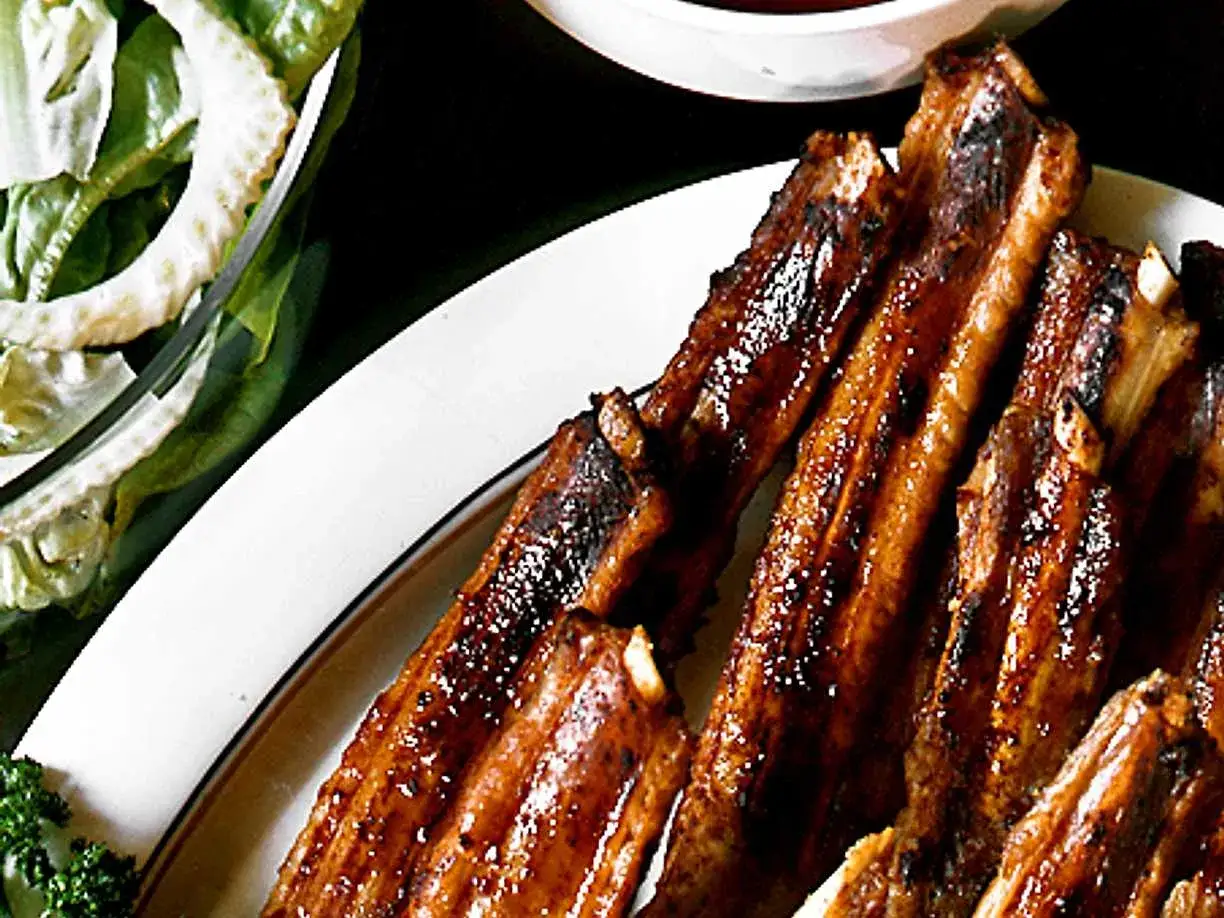Saftiga grillade spareribs serveras med en fräsch sallad. Perfekt för en sommarkväll!