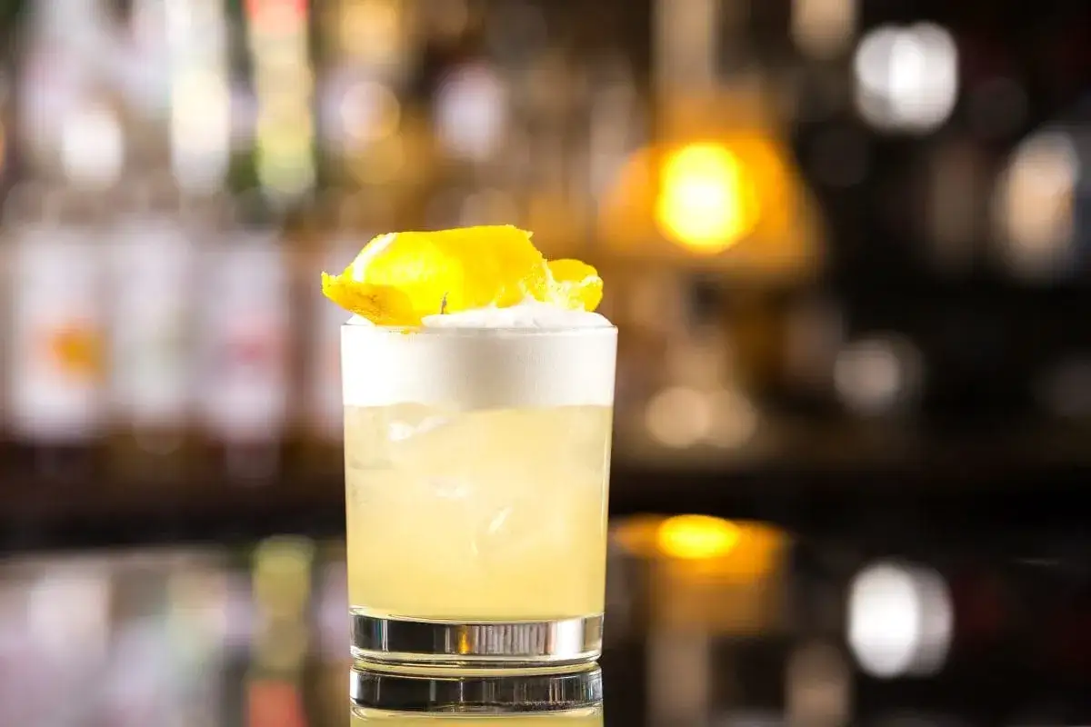 Klasyczny whisky sour przepis: orzeźwiający koktajl z pianką i skórką cytryny, idealny na każdą okazję.